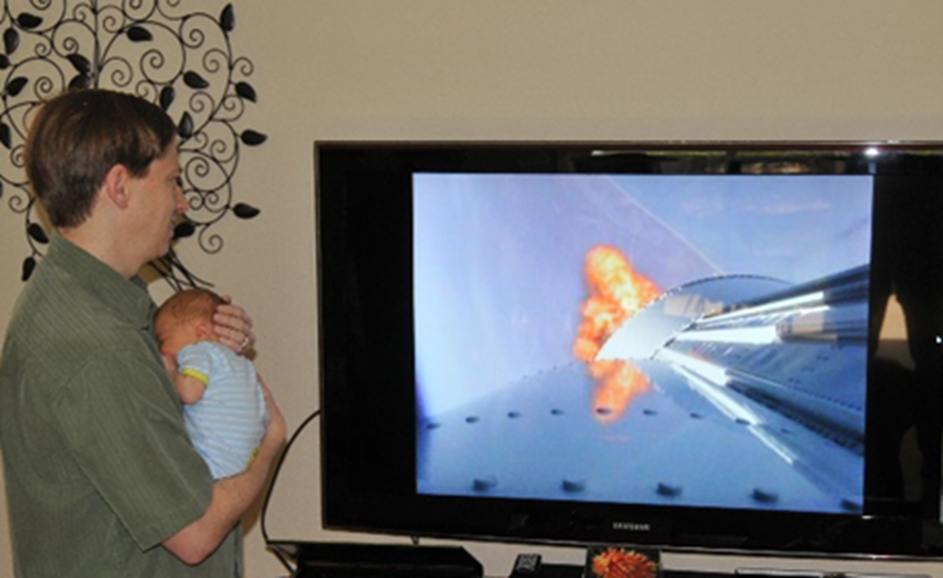 Johnathon考德威尔握着刚出生的儿子,他看着SBIRS GEO-1 2011年的发射